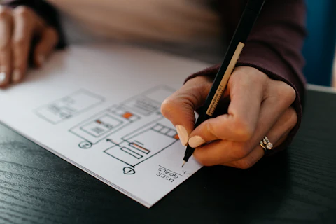Hand sketching a design layout with a pen
